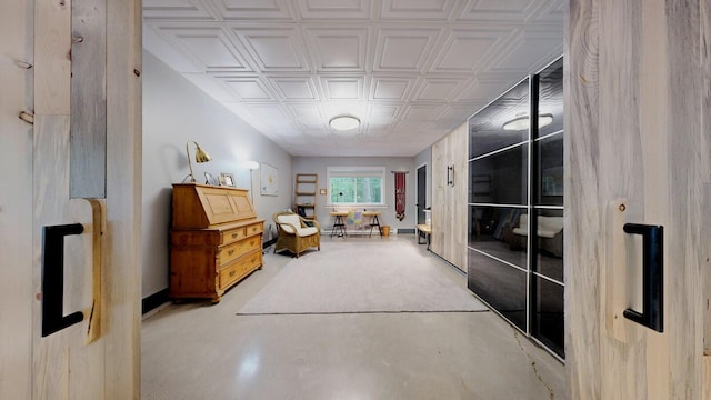 interior space featuring an ornate ceiling and concrete flooring