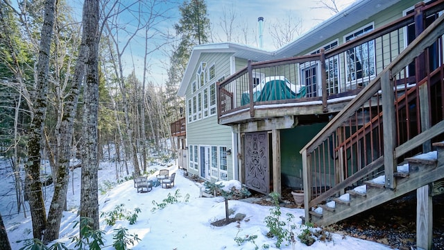 snow covered property with stairs