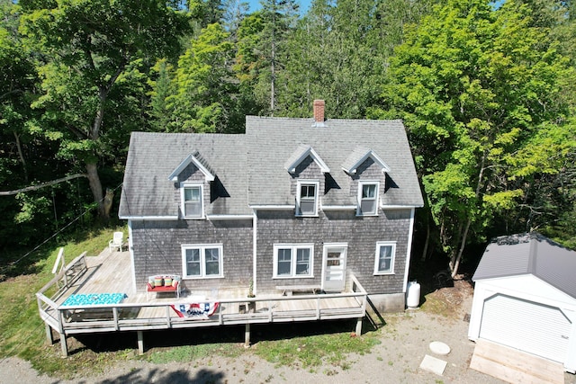 11 Sardine Way, Lubec, ME 04652 - exterior space with an outdoor structure, a deck, roof with shingles, a chimney, and a forest view