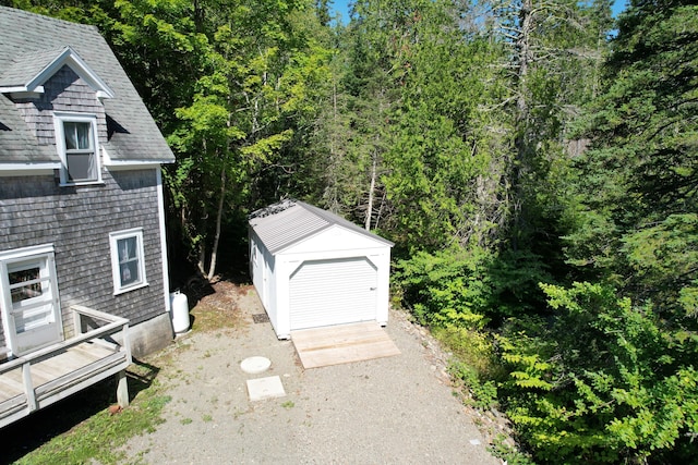 11 Sardine Way, Lubec, ME 04652 - view of home's exterior featuring a wooded view, an outbuilding, a shingled roof, and a shed
