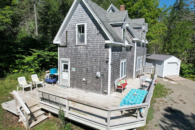 11 Sardine Way, Lubec, ME 04652 - back of property featuring an outdoor structure, a wooden deck, roof with shingles, a chimney, and a storage unit