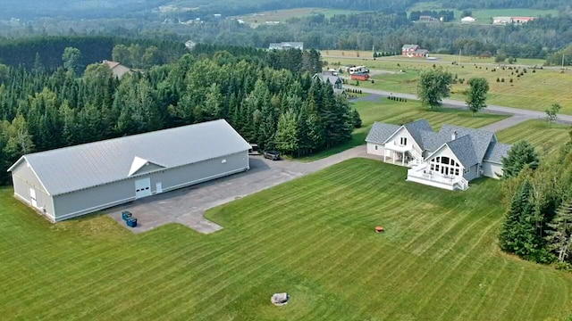 birds eye view of property featuring a rural view and a wooded view