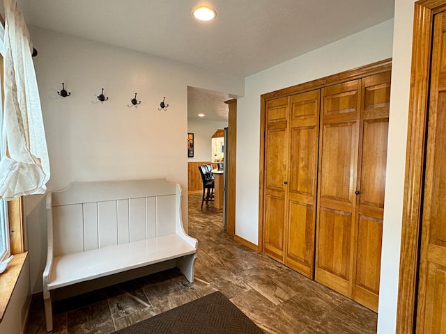 mudroom featuring recessed lighting, arched walkways, and baseboards