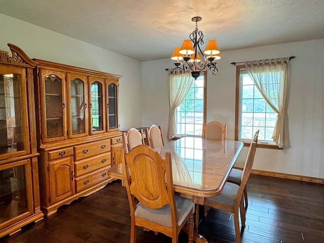 dining room featuring baseboards, dark wood-type flooring, a textured ceiling, and a notable chandelier