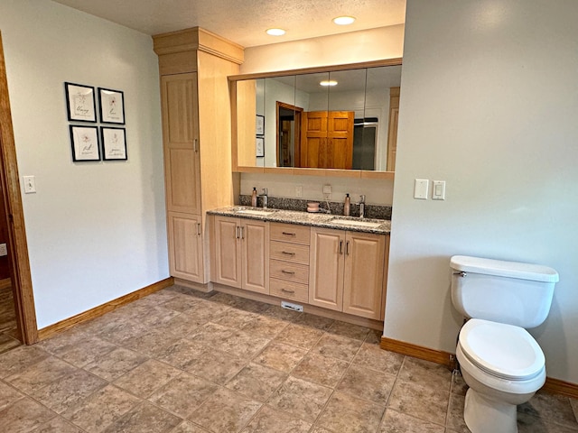 full bath with a sink, toilet, and baseboards