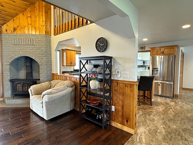 living room featuring dark wood finished floors, lofted ceiling, a wainscoted wall, wood walls, and recessed lighting