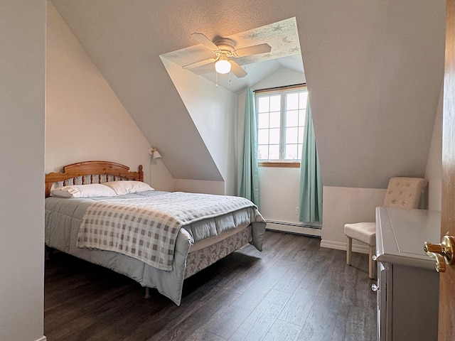 bedroom featuring a baseboard heating unit, wood finished floors, lofted ceiling, and a ceiling fan