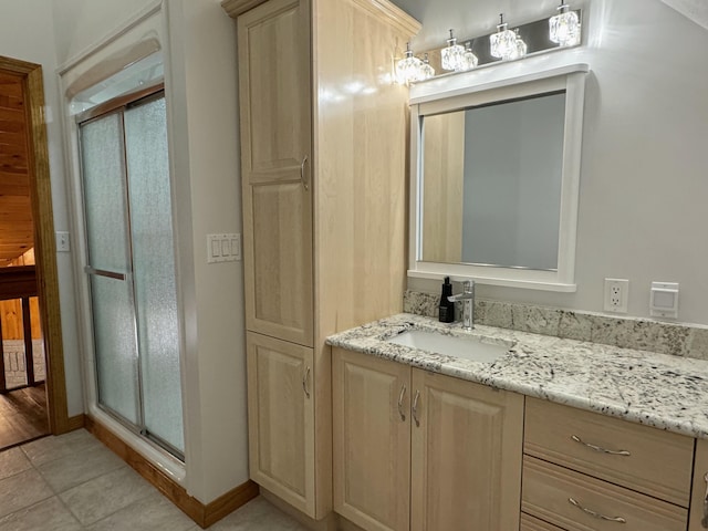 bathroom with a shower stall, vanity, and tile patterned floors