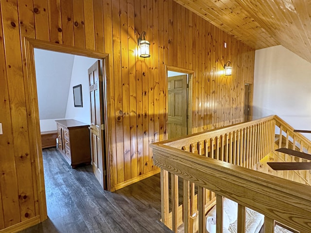 corridor with lofted ceiling, wood ceiling, wooden walls, and wood finished floors