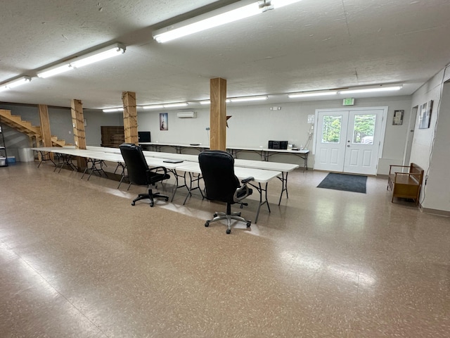 office area with a textured ceiling and an AC wall unit