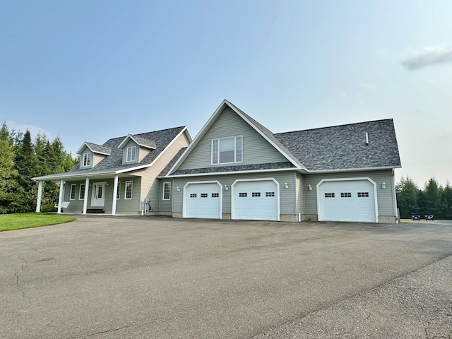 view of front of house with an attached garage, a porch, aphalt driveway, and roof with shingles