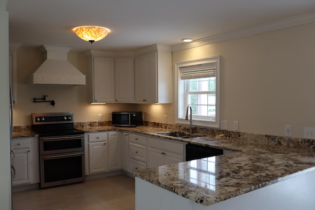 kitchen featuring appliances with stainless steel finishes, white cabinetry, dark stone counters, kitchen peninsula, and premium range hood