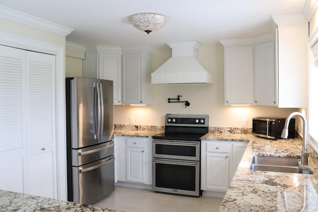 kitchen with white cabinets, stainless steel appliances, crown molding, premium range hood, and sink