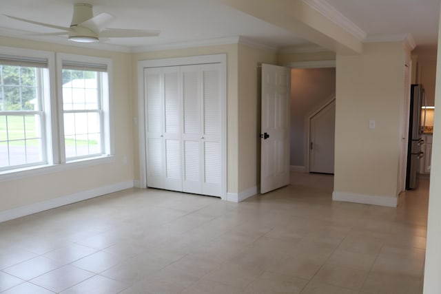 interior space featuring stainless steel refrigerator, crown molding, ceiling fan, and a closet