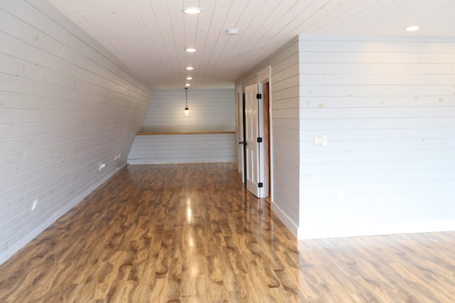 hallway with wooden ceiling, wooden walls, and dark hardwood / wood-style flooring