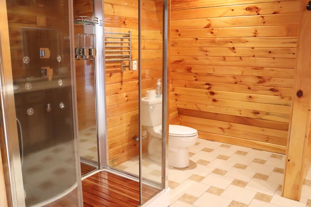 bathroom with wooden walls, toilet, and an enclosed shower