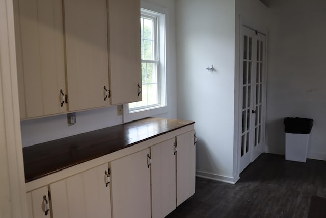 kitchen with a wealth of natural light, dark hardwood / wood-style flooring, and white cabinetry