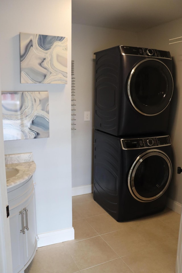 laundry room featuring stacked washer and dryer and light tile patterned floors