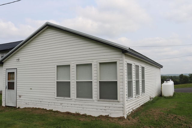 view of side of home with a yard