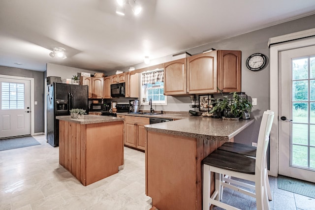 kitchen featuring light tile patterned flooring, sink, plenty of natural light, and black appliances