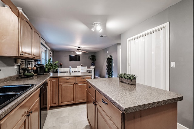 kitchen with black dishwasher, light tile patterned floors, sink, a kitchen island, and ceiling fan