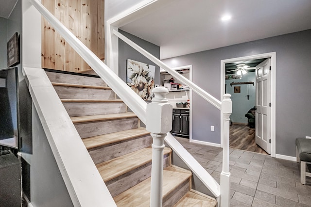 staircase featuring ceiling fan and wood-type flooring