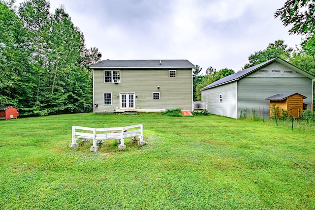 back of property featuring an outdoor structure and a yard