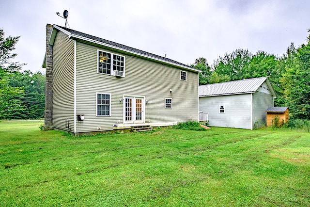 back of house with french doors, an outdoor structure, and a lawn