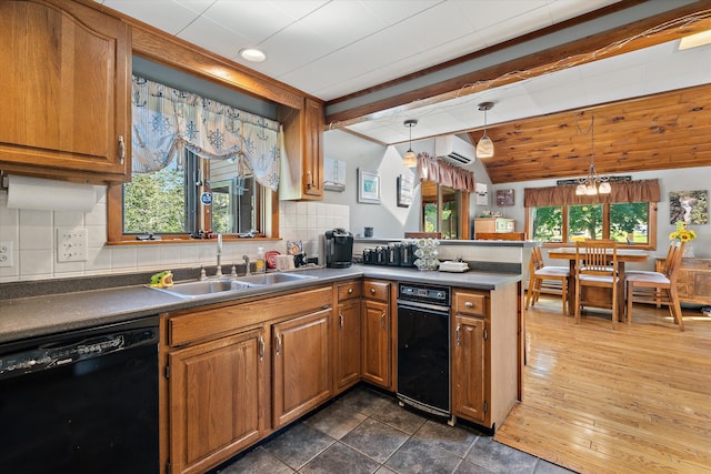 kitchen featuring black dishwasher, brown cabinets, dark countertops, a sink, and a peninsula