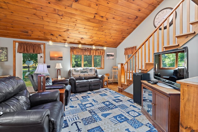 living area featuring lofted ceiling, wooden ceiling, stairs, and a wealth of natural light