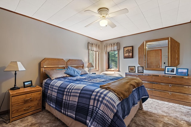 carpeted bedroom featuring ceiling fan and ornamental molding