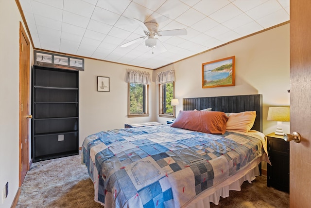 bedroom with ceiling fan, ornamental molding, and dark carpet