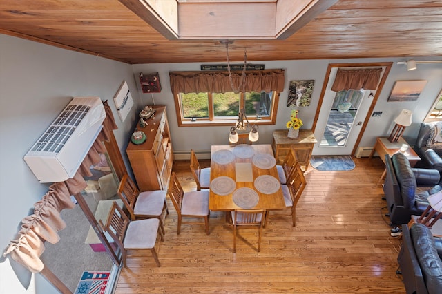 dining area featuring a baseboard heating unit, wood ceiling, and light wood-style floors