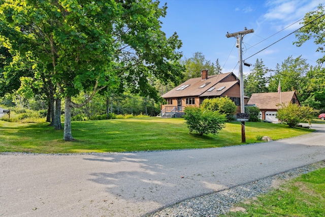 view of front of home featuring a garage, a chimney, and a front lawn