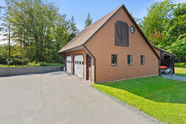 view of property exterior with a garage, a lawn, and an outdoor structure