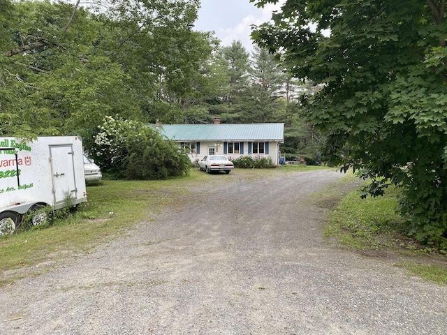 view of front of property featuring metal roof and driveway