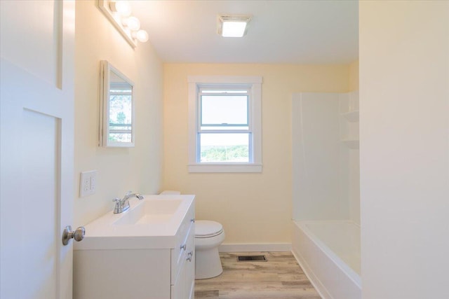 full bathroom with bathtub / shower combination, toilet, vanity, and wood-type flooring