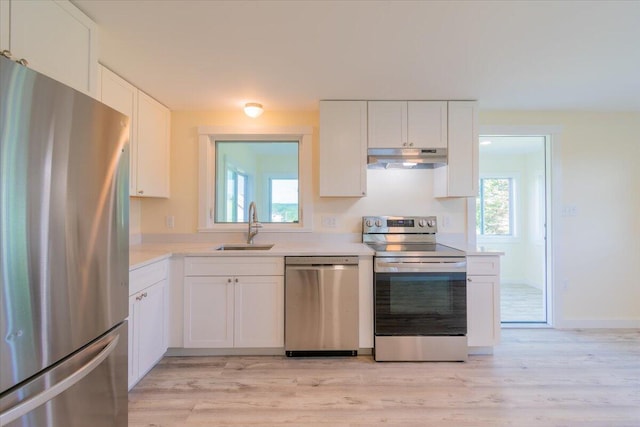 kitchen featuring sink, stainless steel appliances, light hardwood / wood-style floors, and white cabinets