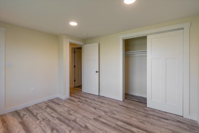 unfurnished bedroom with light hardwood / wood-style floors and a closet