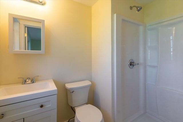 bathroom with toilet, a shower, and vanity