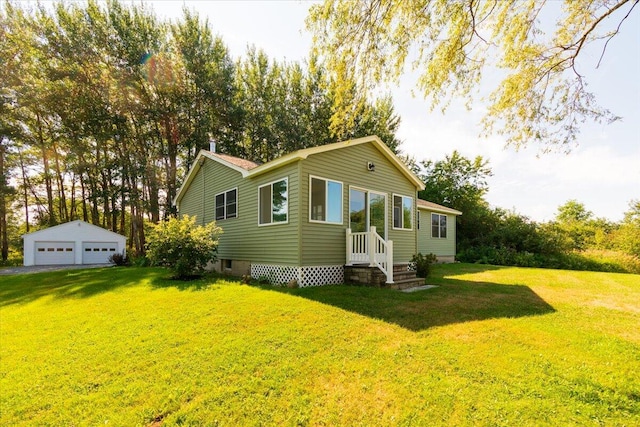 view of side of home featuring a lawn, a garage, and an outbuilding