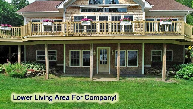 back of property with a lawn and a wooden deck