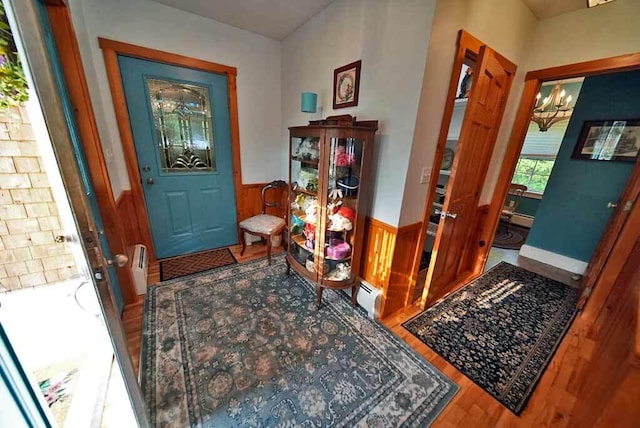 foyer with hardwood / wood-style flooring and a baseboard heating unit