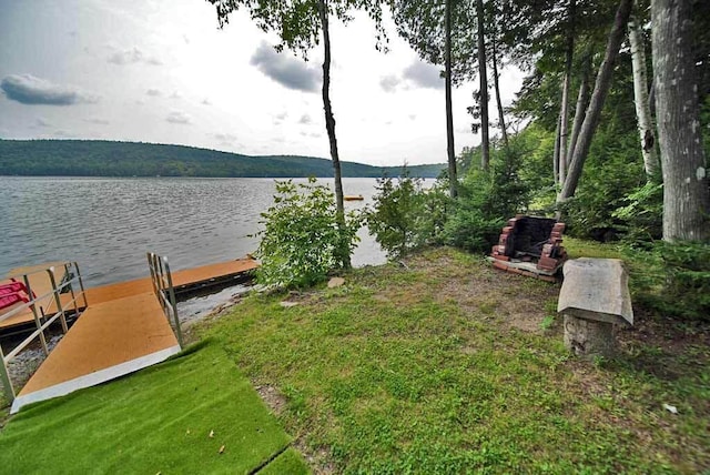 dock area featuring a water view and a lawn