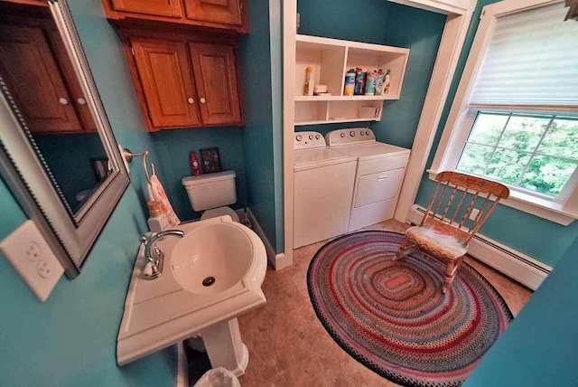 bathroom featuring washer and dryer, sink, toilet, and a baseboard radiator