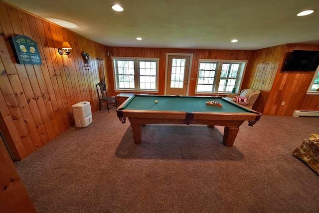 recreation room with carpet, wood walls, plenty of natural light, and baseboard heating