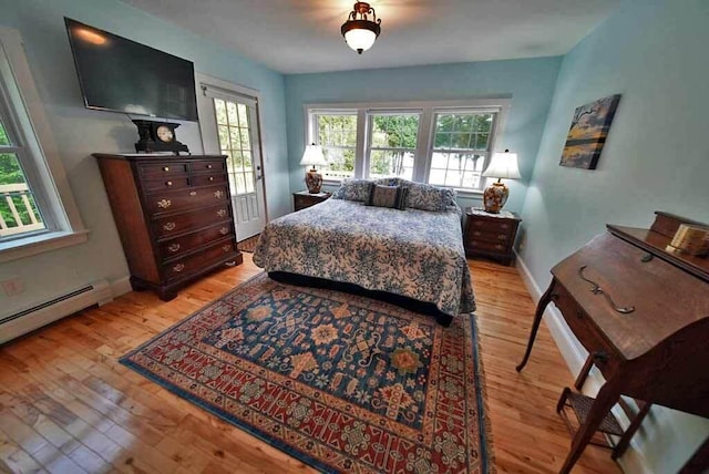 bedroom with light hardwood / wood-style flooring and a baseboard radiator