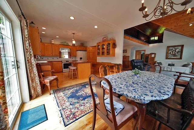 dining space featuring light hardwood / wood-style flooring and lofted ceiling