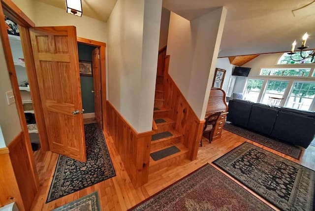 interior space featuring hardwood / wood-style flooring, vaulted ceiling, and an inviting chandelier