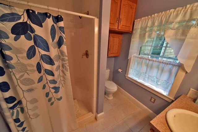 bathroom with tile patterned flooring, toilet, vanity, and walk in shower